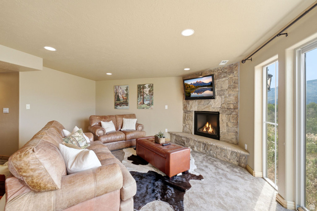 5404 Mountain View Road Coalville, UT 84017 - Photo 34 of 50 Corner fireplace with stone surround and hearth, recessed lighting, and expansive windows