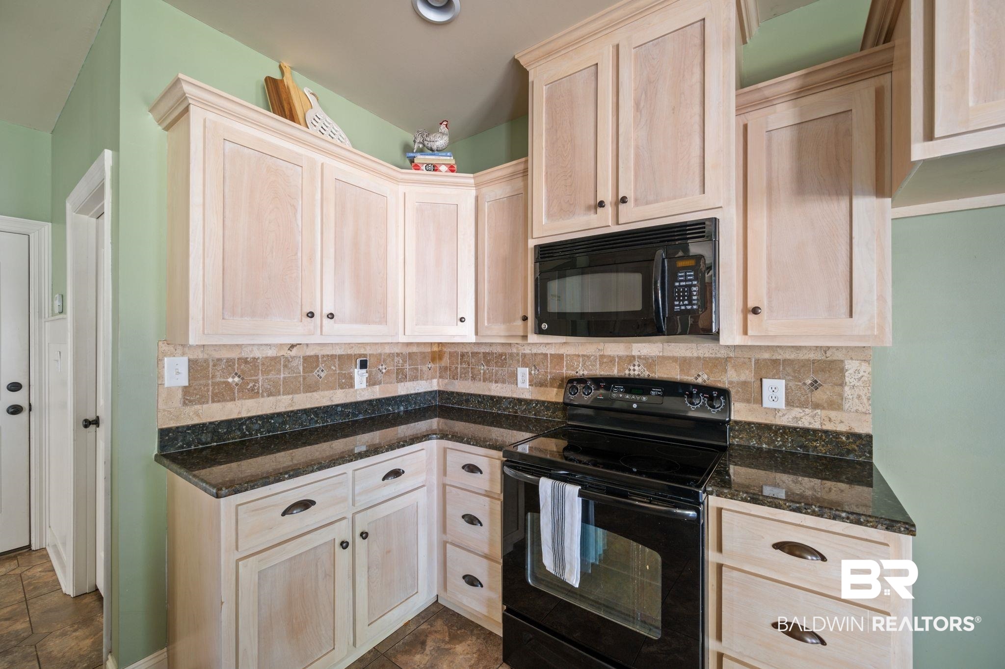 3879 Symphony Way West Semmes, AL 36575 - Photo 12 of 34 Kitchen featuring backsplash, dark tile patterned floors, light brown cabinetry, and black appliances