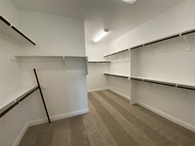 en empty room with windows and ceiling fan