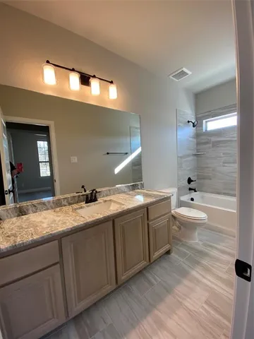 a bathroom with a granite countertop sink mirror and toilet
