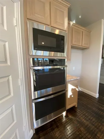 a kitchen with center island wooden floor and stainless steel appliances