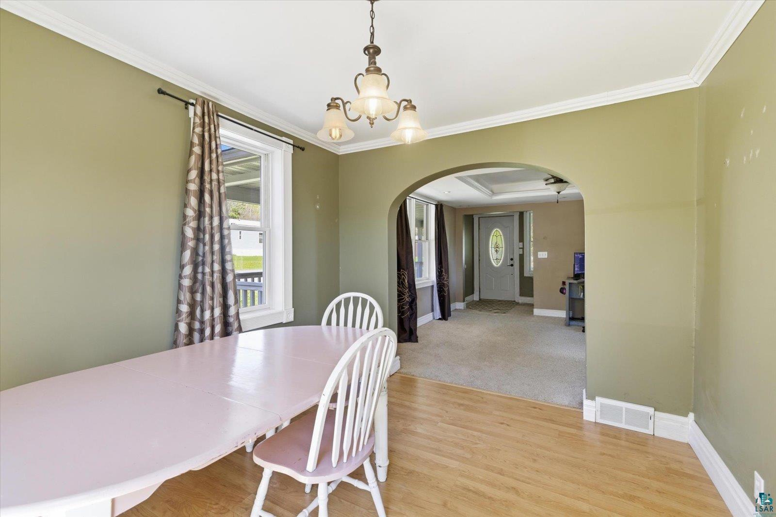 50 Main Street Soudan, MN 55782 - Photo 6 of 31 Dining area featuring wood-finish flooring, a window with exterior visibility, and crown molding
