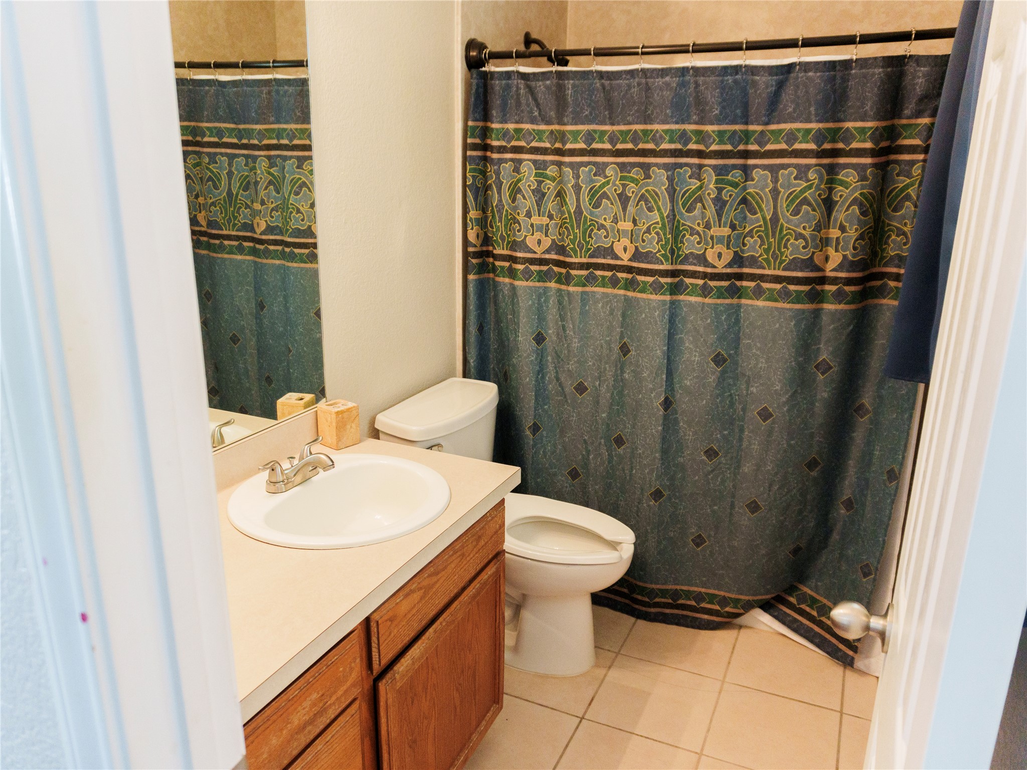800 Debra Drive Taylor, TX 76574 - Photo 14 of 17 Bathroom with light tile patterned flooring, vanity, and a shower with curtain