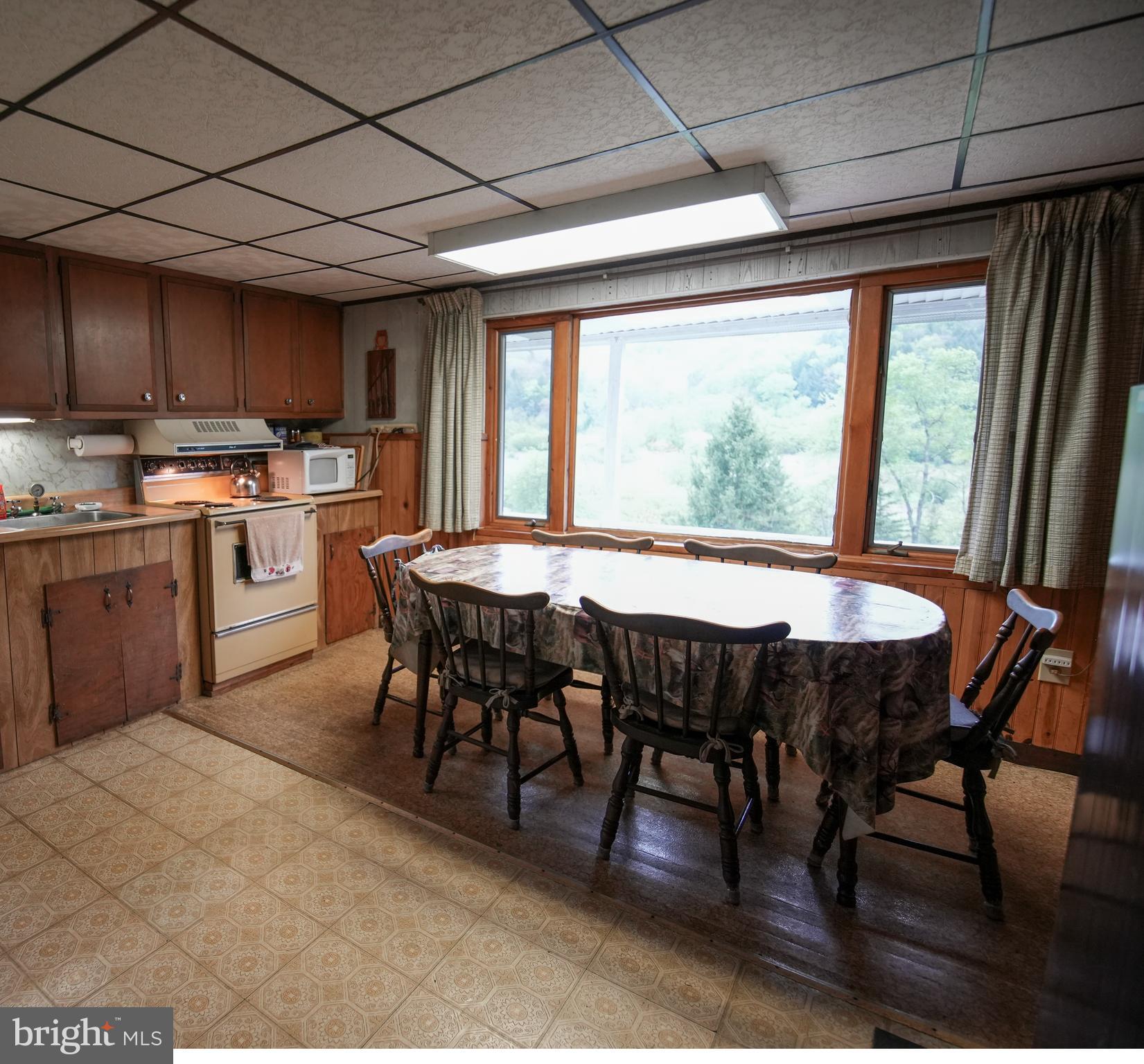 1315 1st Fork Road Austin, PA 16720 - Photo 11 of 25 a dining room with stainless steel appliances granite countertop a sink a stove a dining table and chairs