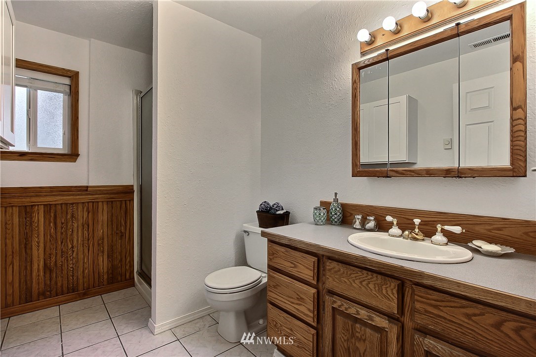7370 Bordeaux Road Southwest Olympia, WA 98512 - Photo 16 of 25 a bathroom with a granite countertop sink a toilet and mirror