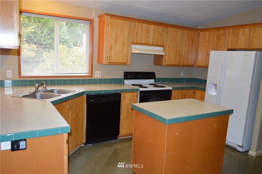 7370 Bordeaux Road Southwest Olympia, WA 98512 - Photo 21 of 25 a kitchen with stainless steel appliances granite countertop a sink stove and refrigerator