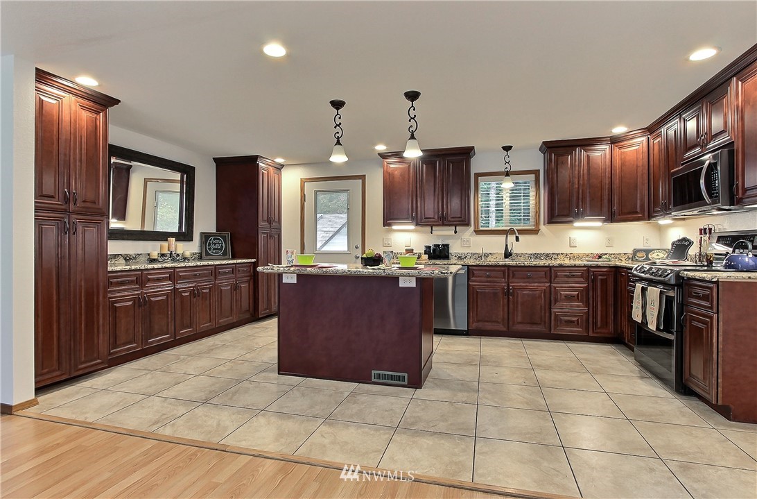 7370 Bordeaux Road Southwest Olympia, WA 98512 - Photo 8 of 25 a large kitchen with granite countertop a large counter top stainless steel appliances and cabinets