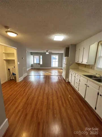 a view of a kitchen with wooden floor and electronic appliances