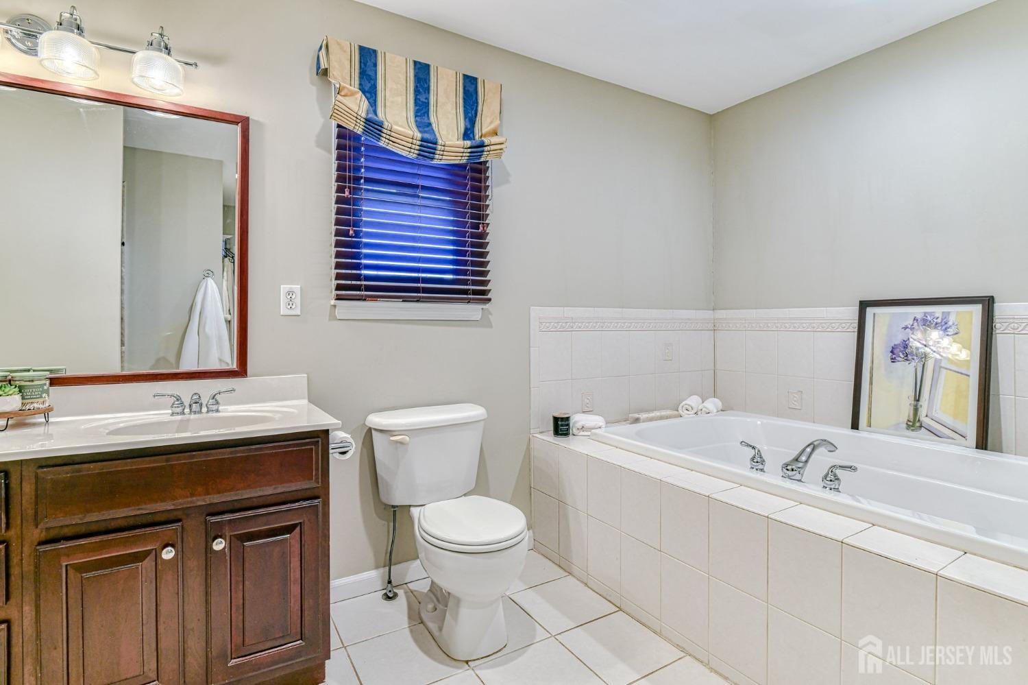 10 Graulich Drive Milltown, NJ 08850 - Photo 29 of 40 a bathroom with a sink a toilet and mirror