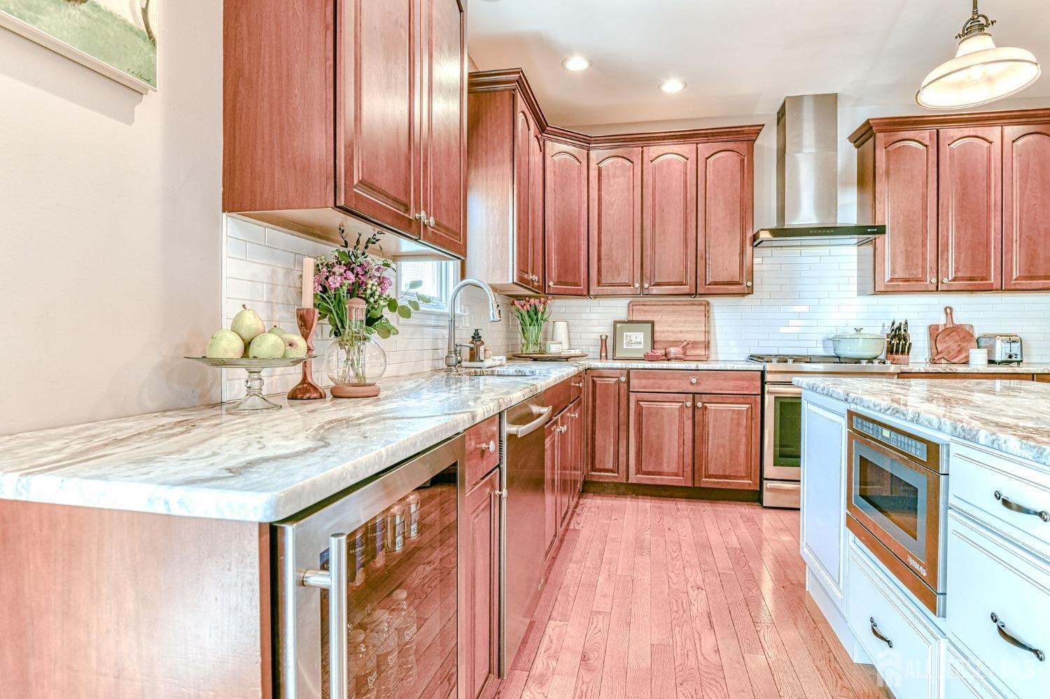 10 Graulich Drive Milltown, NJ 08850 - Photo 6 of 40 a kitchen with stainless steel appliances granite countertop wooden cabinets a sink and dishwasher a stove top oven with wooden floor
