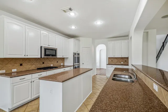 a kitchen with sink a stove and cabinets