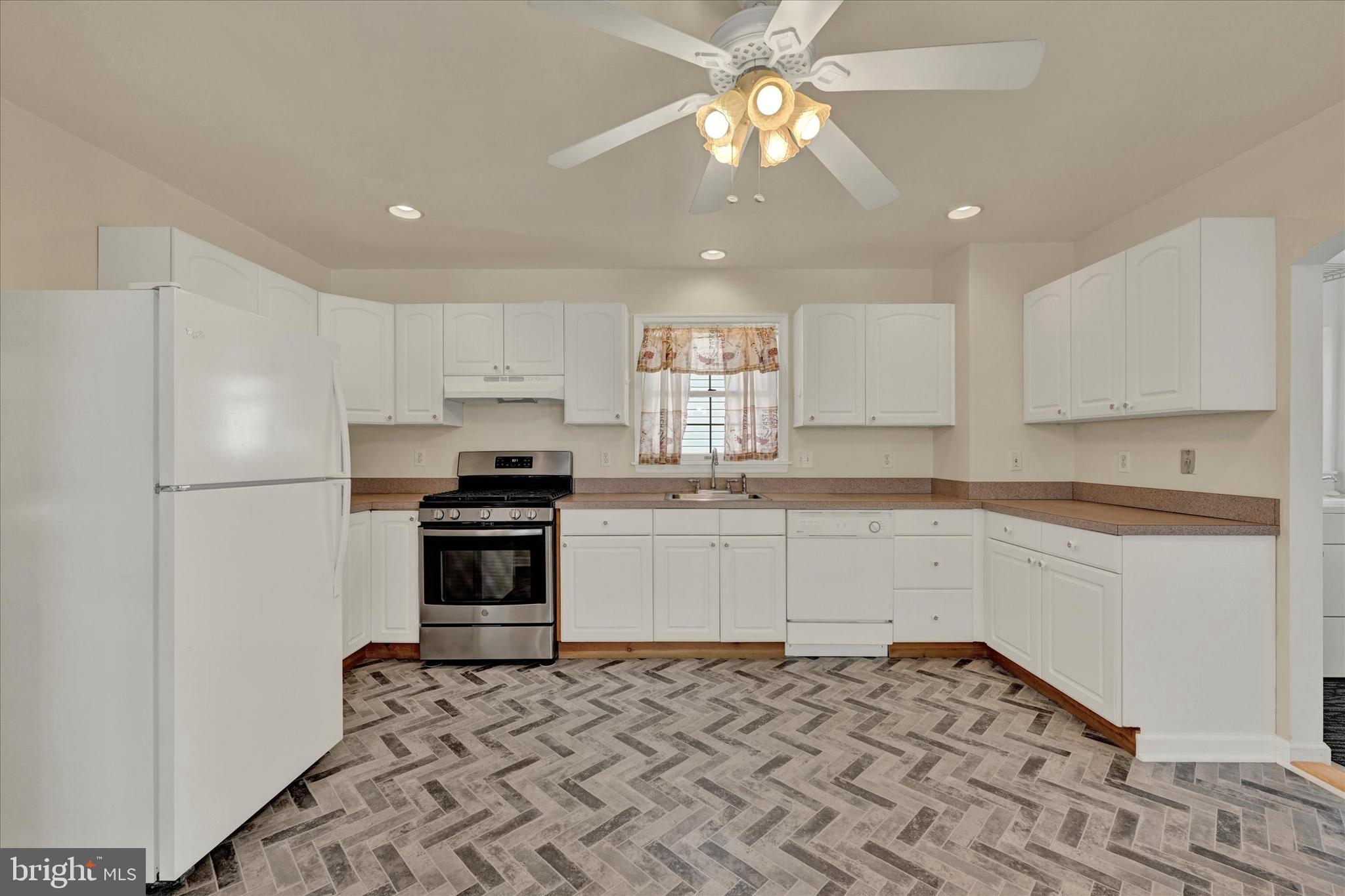 1203 Fairfield Avenue Baltimore, MD 21209 - Photo 12 of 32 a kitchen with granite countertop a refrigerator stove top oven and sink