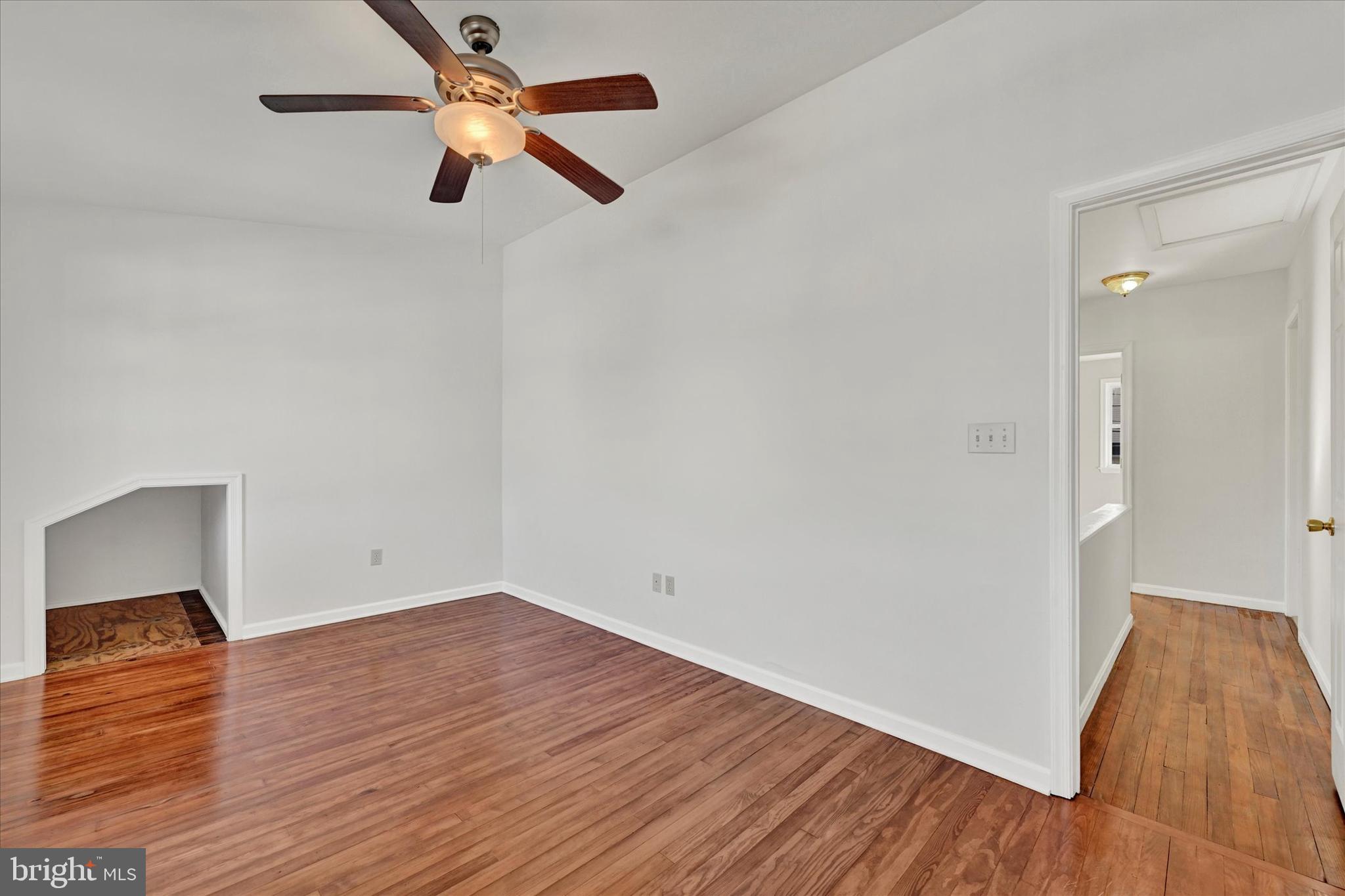 1203 Fairfield Avenue Baltimore, MD 21209 - Photo 17 of 32 an empty room with wooden floor and fan