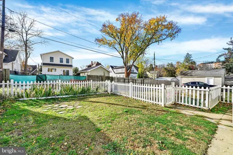 a view of a house with a small yard and a large tree