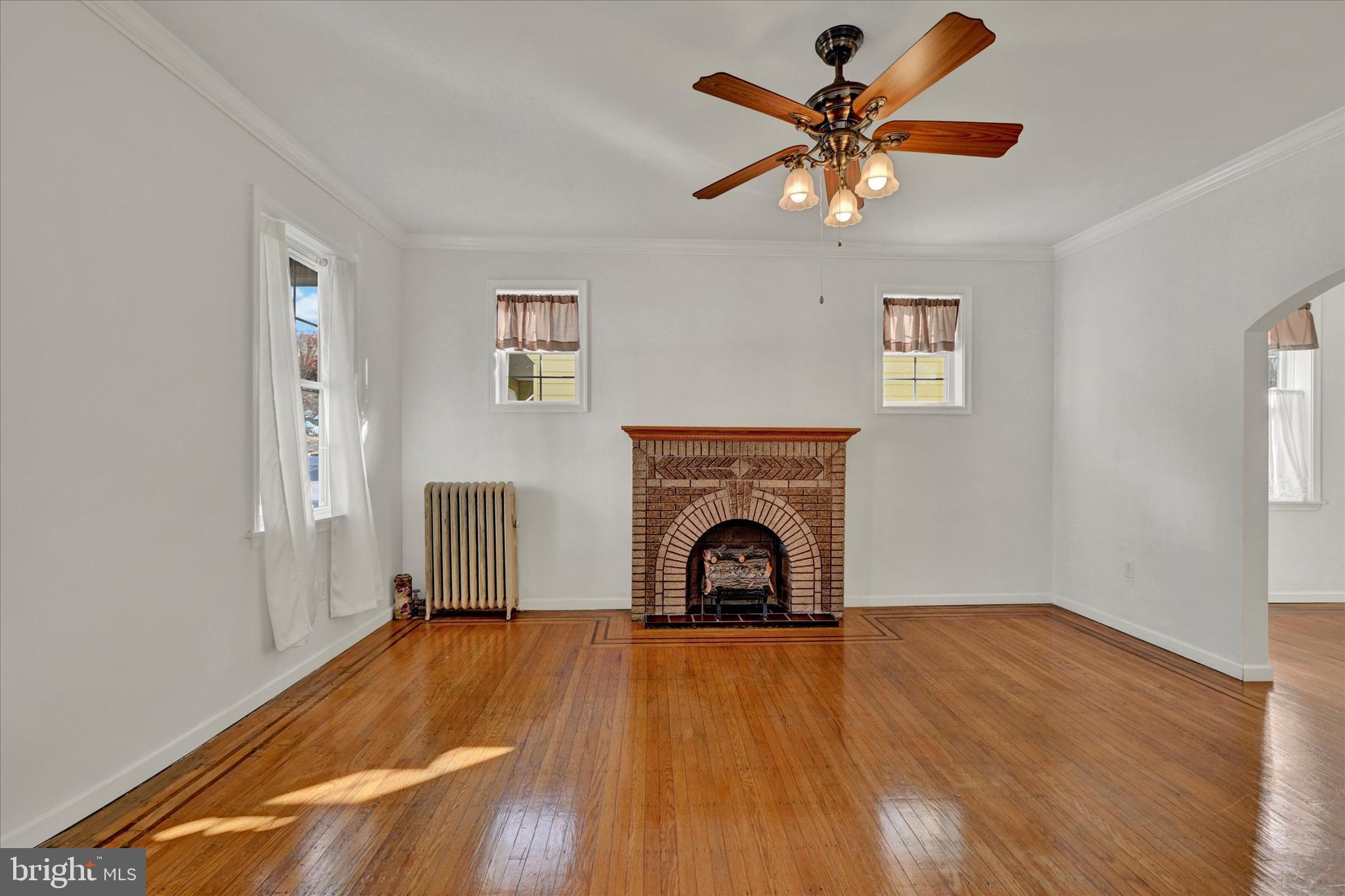 1203 Fairfield Avenue Baltimore, MD 21209 - Photo 5 of 32 a view of empty room with fireplace and wooden floor