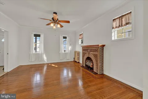 a living room with wooden floor a fireplace and a window