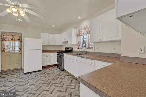 a kitchen with a sink a stove a refrigerator and cabinets