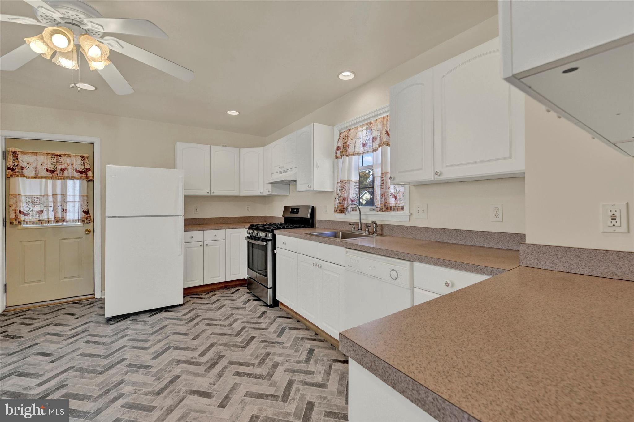 1203 Fairfield Avenue Baltimore, MD 21209 - Photo 9 of 32 a kitchen with a sink a stove a refrigerator and cabinets