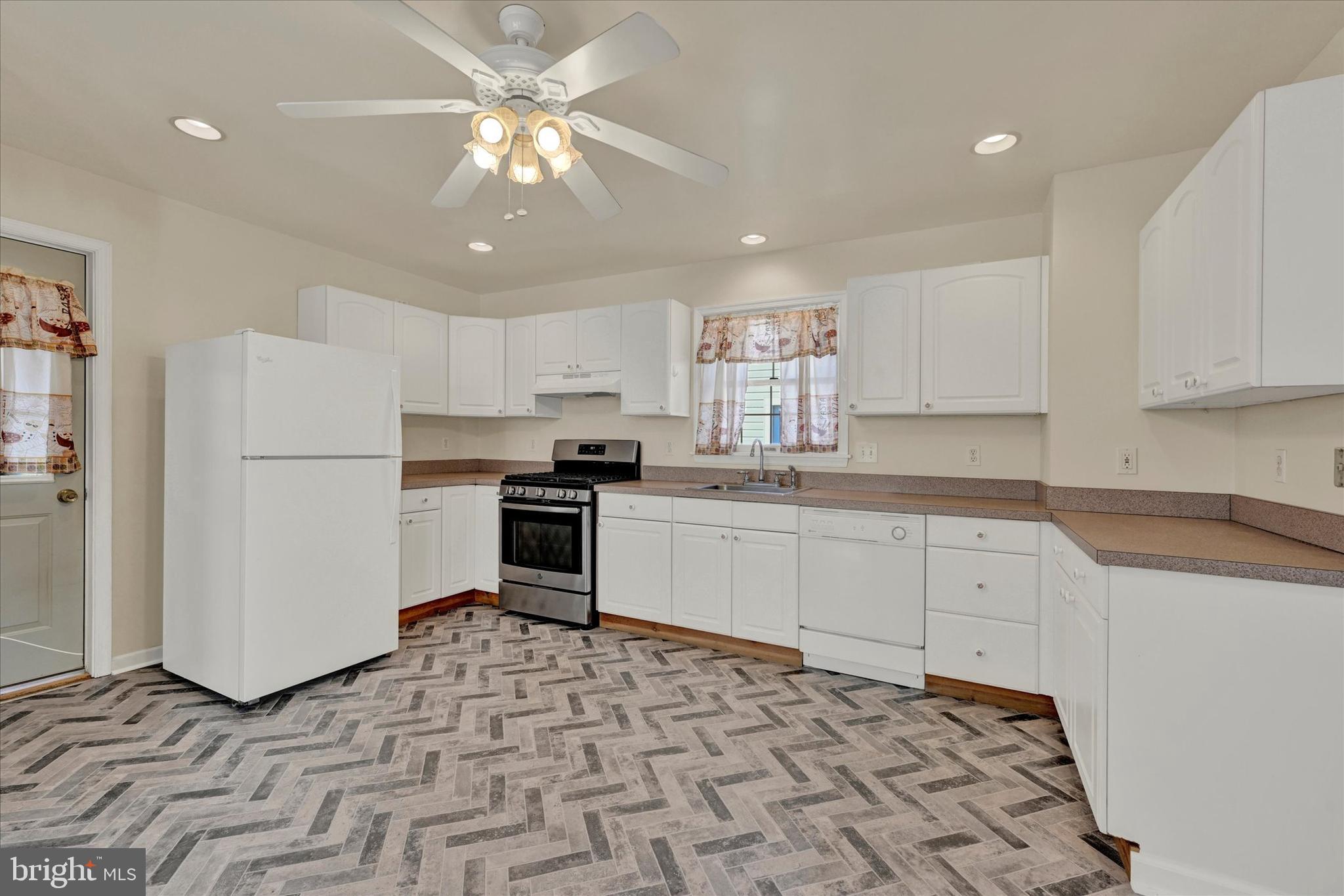 1203 Fairfield Avenue Baltimore, MD 21209 - Photo 10 of 32 a kitchen with stainless steel appliances granite countertop a refrigerator sink and white cabinets