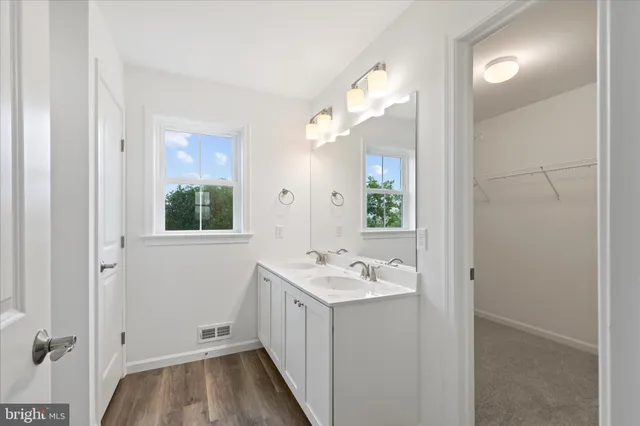 a bathroom with a sink a mirror and a window