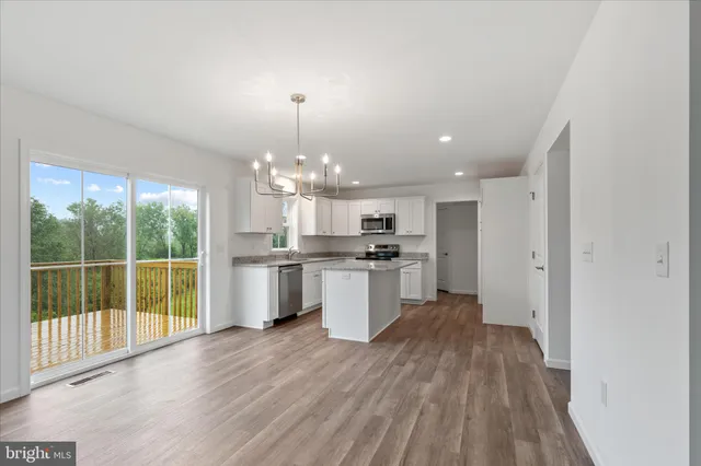 a view of a kitchen with granite countertop stainless steel appliances and a large window