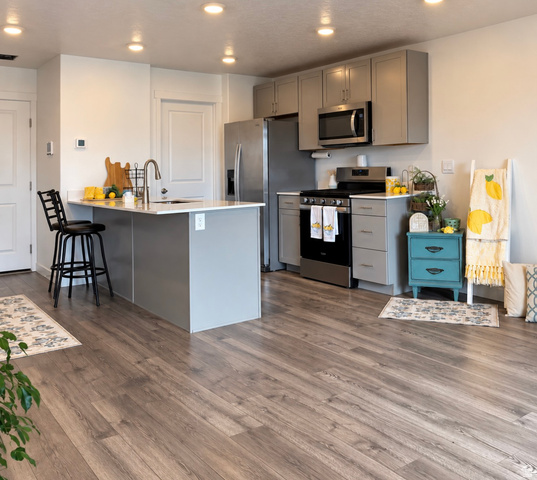 1140 Summit Ridge Parkway Santaquin, UT 84655 - Photo 2 of 29 Open-concept kitchen featuring an island with a built-in sink, stainless steel appliances, grey cabinetry