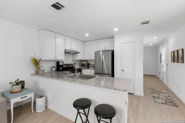 a kitchen with stainless steel appliances granite countertop a sink refrigerator and cabinets