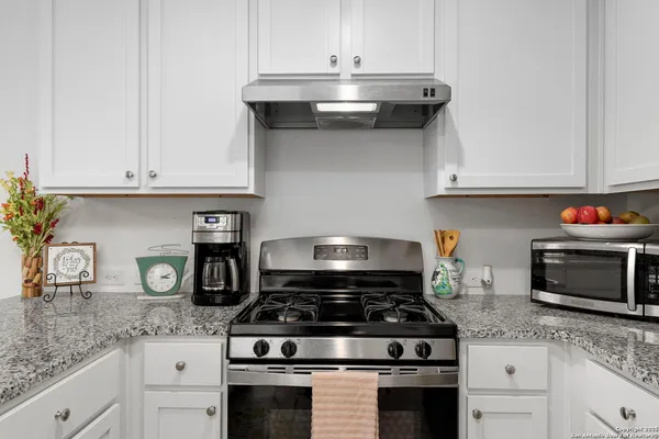 a kitchen with stainless steel appliances granite countertop a refrigerator a stove and a sink