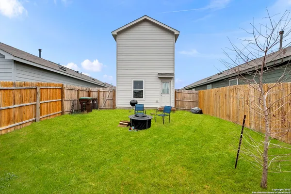 a view of a backyard with table and chairs and wooden fence