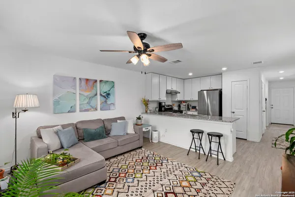 a living room with furniture and a dining table with kitchen view