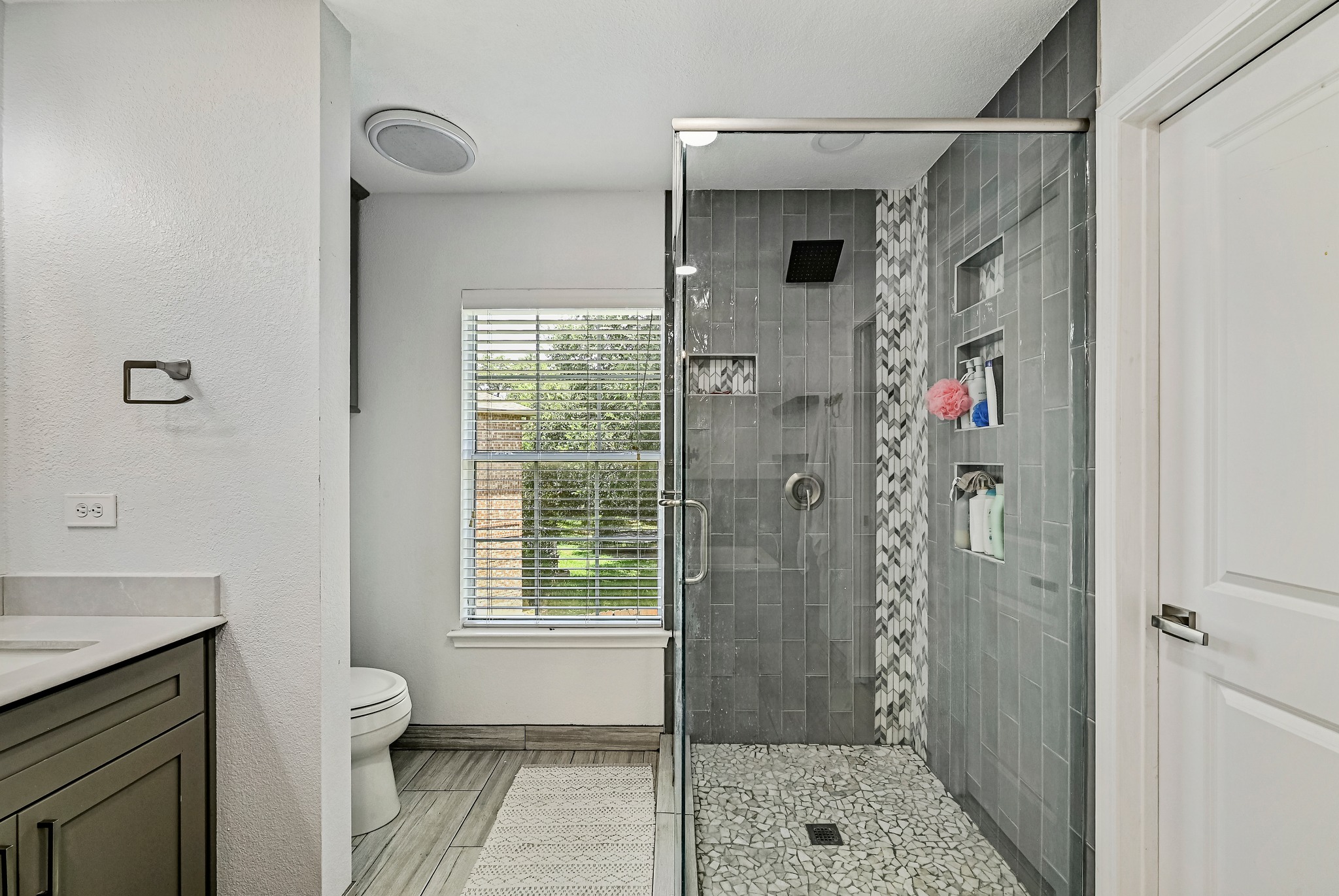 104 North Sumac Lane Georgetown, TX 78633 - Photo 32 of 40 A sleek, contemporary bathroom features a glass-enclosed shower with mosaic tile accents and built-in shelving.