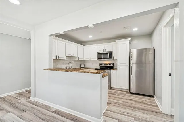 a kitchen with stainless steel appliances granite countertop a refrigerator and a sink