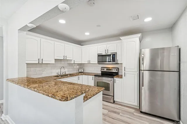 a kitchen with white cabinets and white appliances