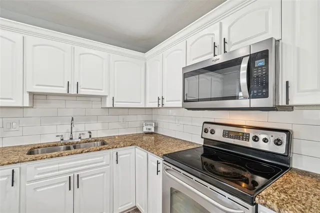 a kitchen with a sink stove and cabinets