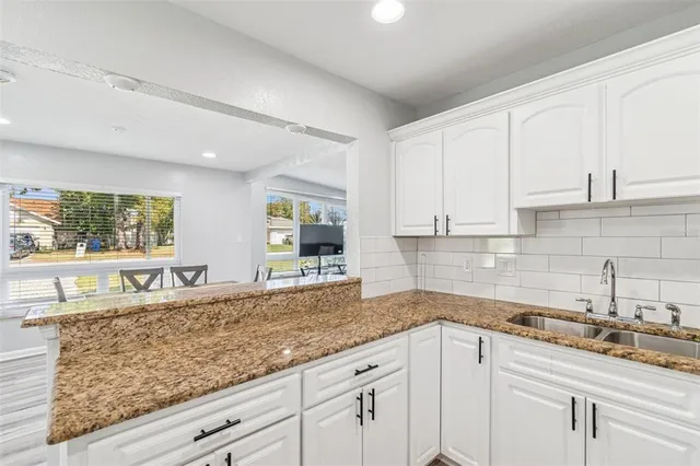 a kitchen with granite countertop a stove microwave and refrigerator