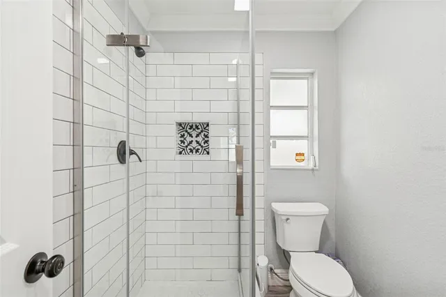 a bathroom with a granite countertop toilet sink and mirror
