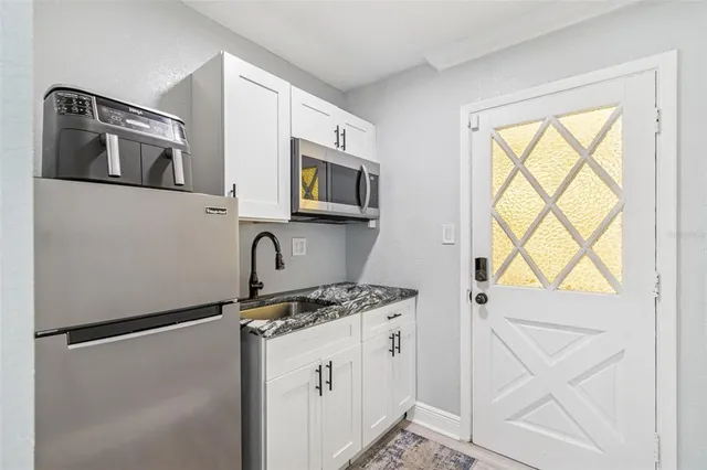 a kitchen with appliances a refrigerator and cabinets