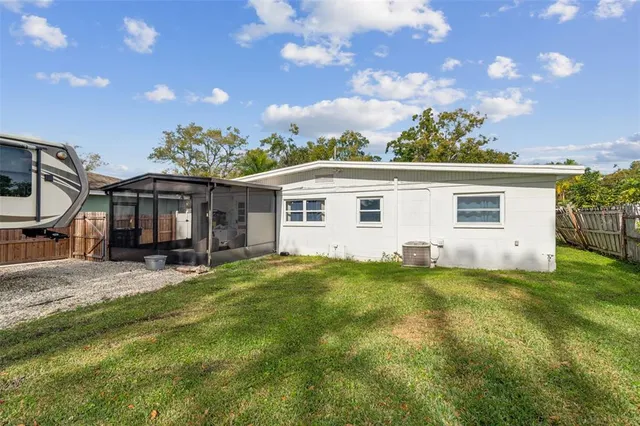 a view of a house with a big yard potted plants and large tree