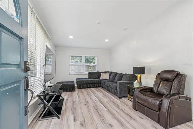 a living room with furniture a dining table and wooden floor
