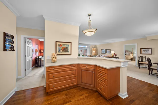 a kitchen with kitchen island granite countertop a sink cabinets and wooden floor