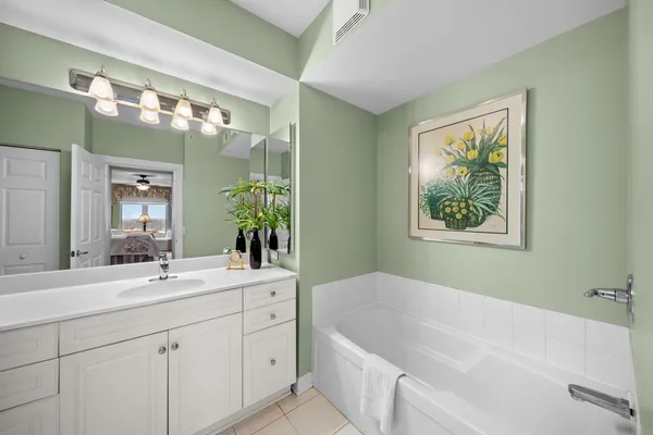a bathroom with a tub a sink and mirror