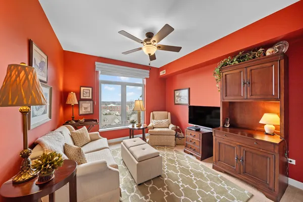 a living room with furniture a ceiling fan and a flat screen tv