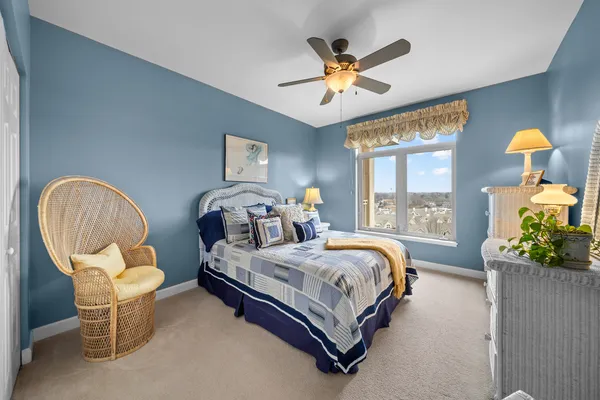 a bedroom with a bed chairs and window