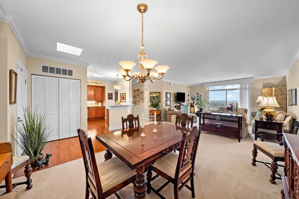 a dining room with furniture potted plants and wooden floor