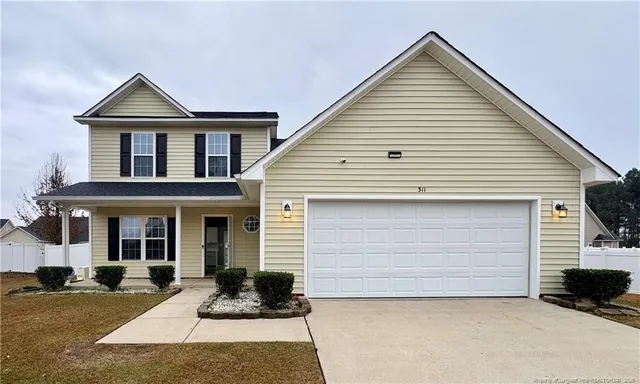 a front view of a house with a yard and garage