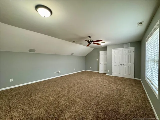 an empty room with an entryway and fan