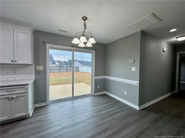 an empty room with wooden floor and cabinet