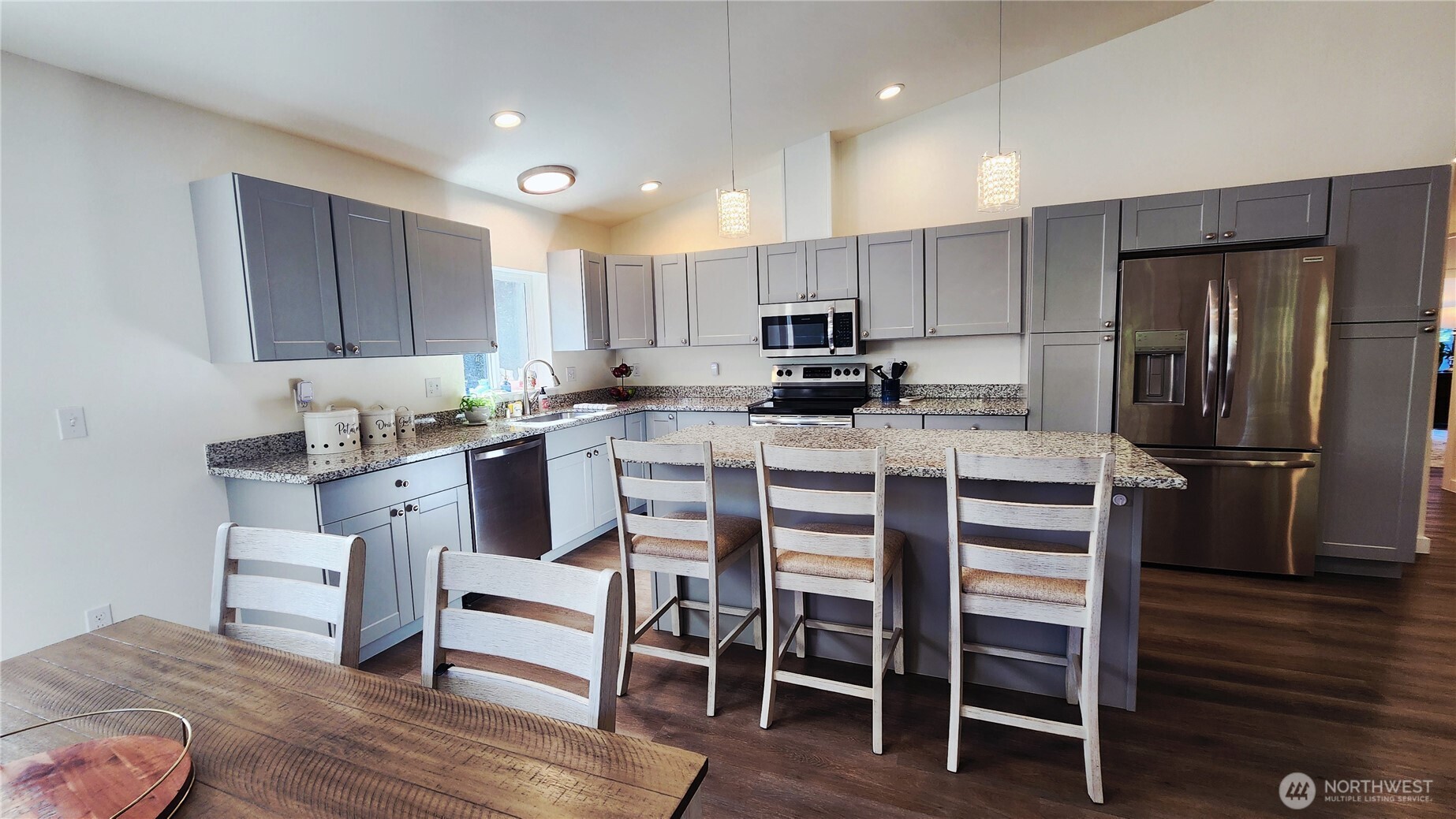 371 Centaurus Avenue Southwest Ocean Shores, WA 98569 - Photo 4 of 40 a kitchen with stainless steel appliances kitchen island granite countertop a table chairs sink refrigerator and microwave
