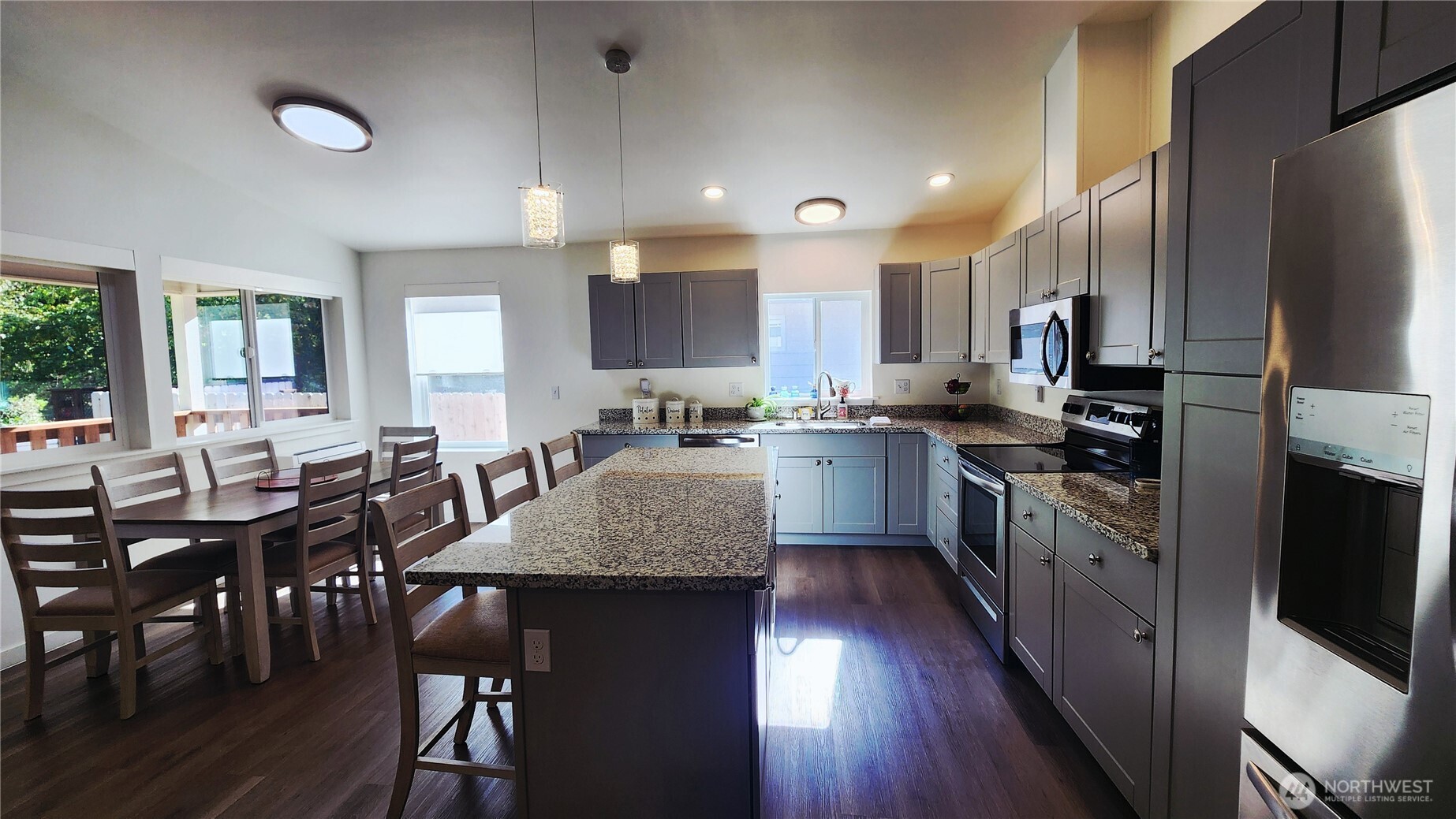 371 Centaurus Avenue Southwest Ocean Shores, WA 98569 - Photo 10 of 40 a kitchen with stainless steel appliances granite countertop a stove a sink a microwave a dining table and chairs