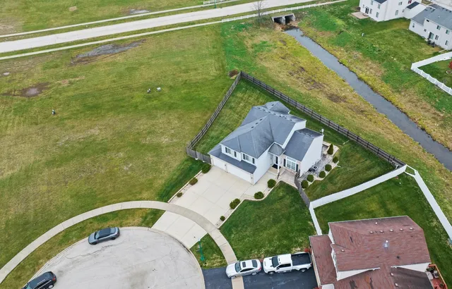 an aerial view of a house with a garden and lake view